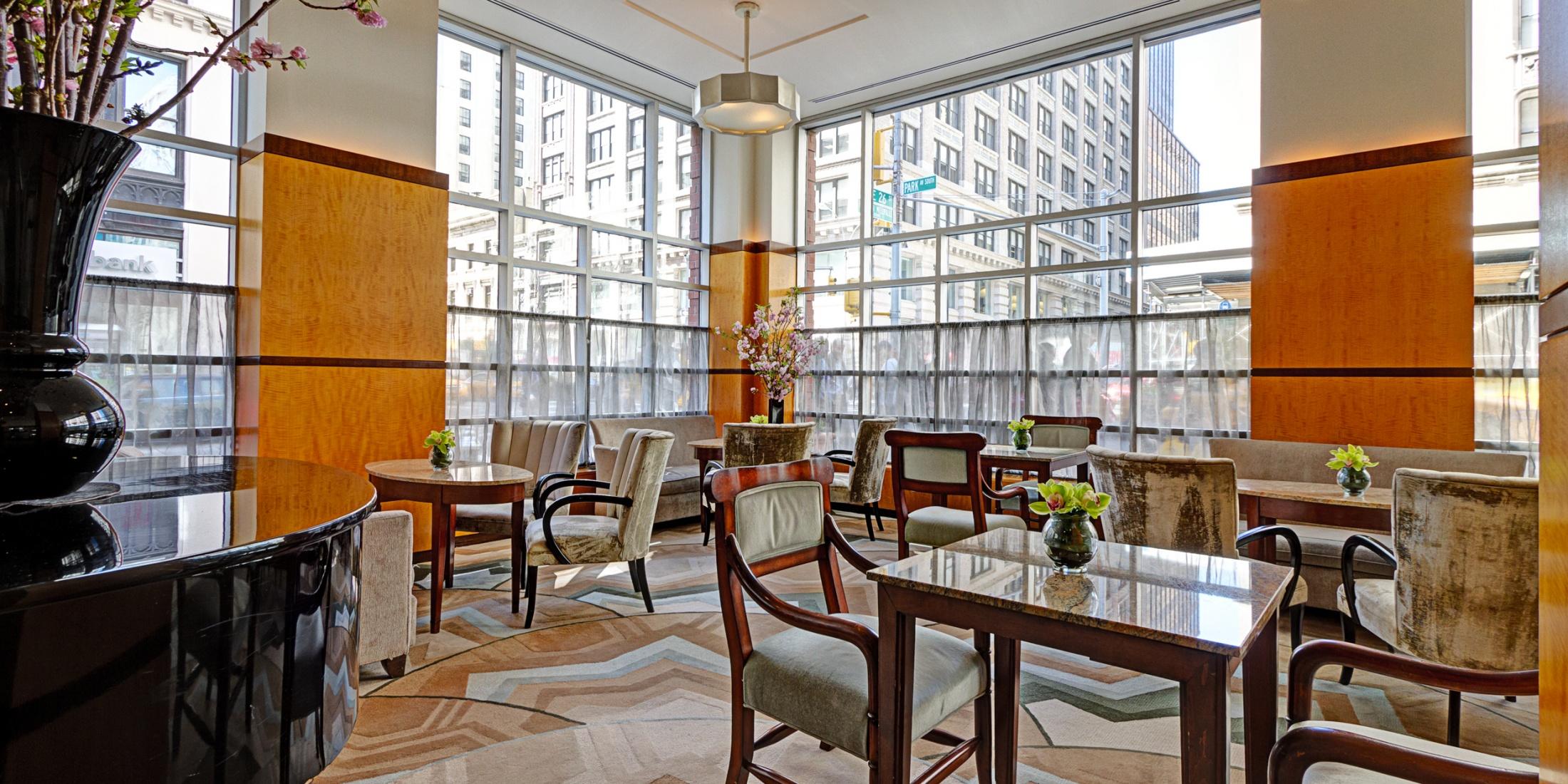 Grand Lobby with plenty of seating, tables, floor-to-ceiling windows, and a grand piano.